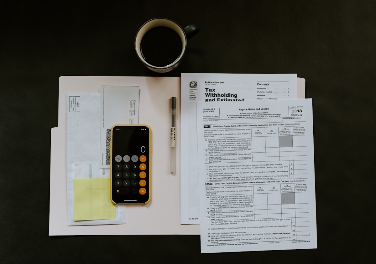 Self-employed person reviewing side hustle tax deductions on a laptop with receipts and a calculator on the desk